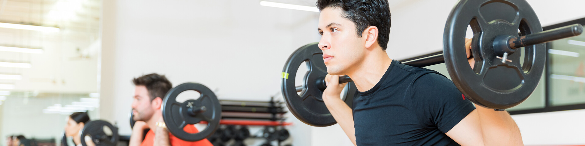 Mann hebt Gewwicht mit Langhantel